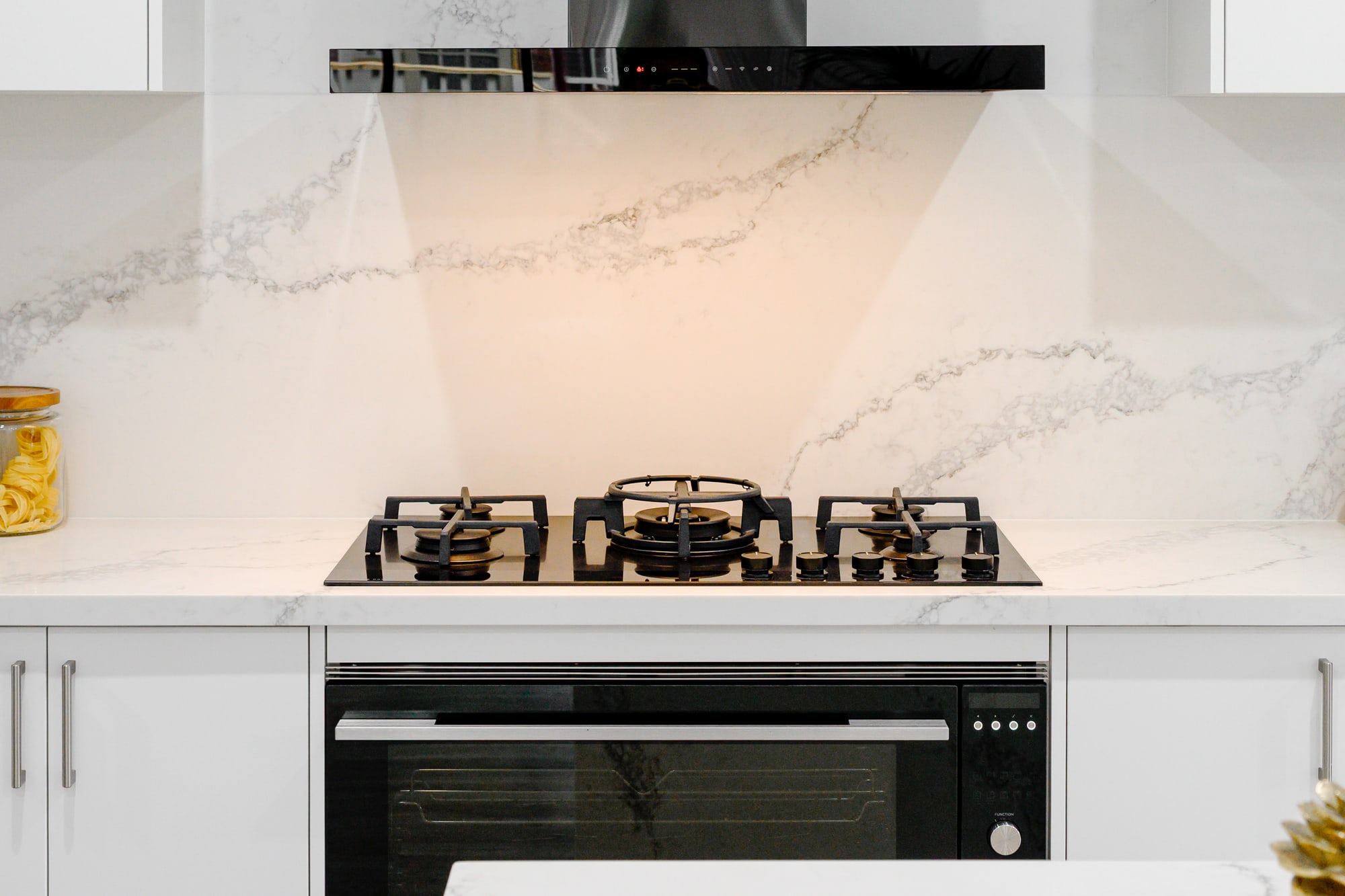 Marble splashback with a gas cooktop and styled benchtop accessories