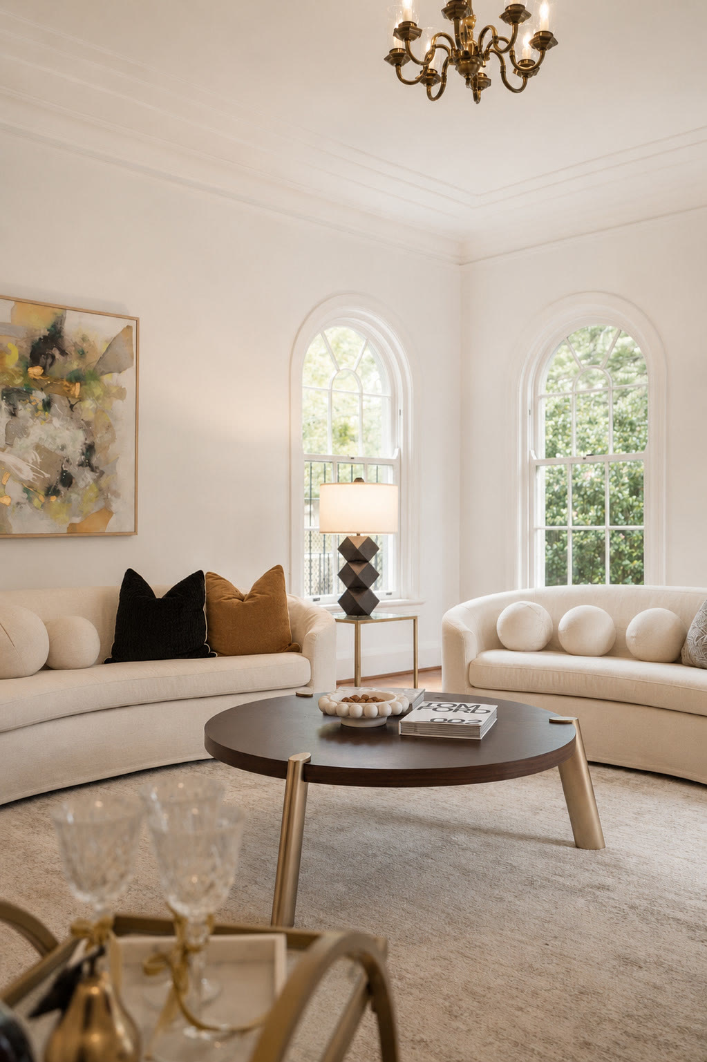 Living room with arched windows, a round coffee table and curved sofas