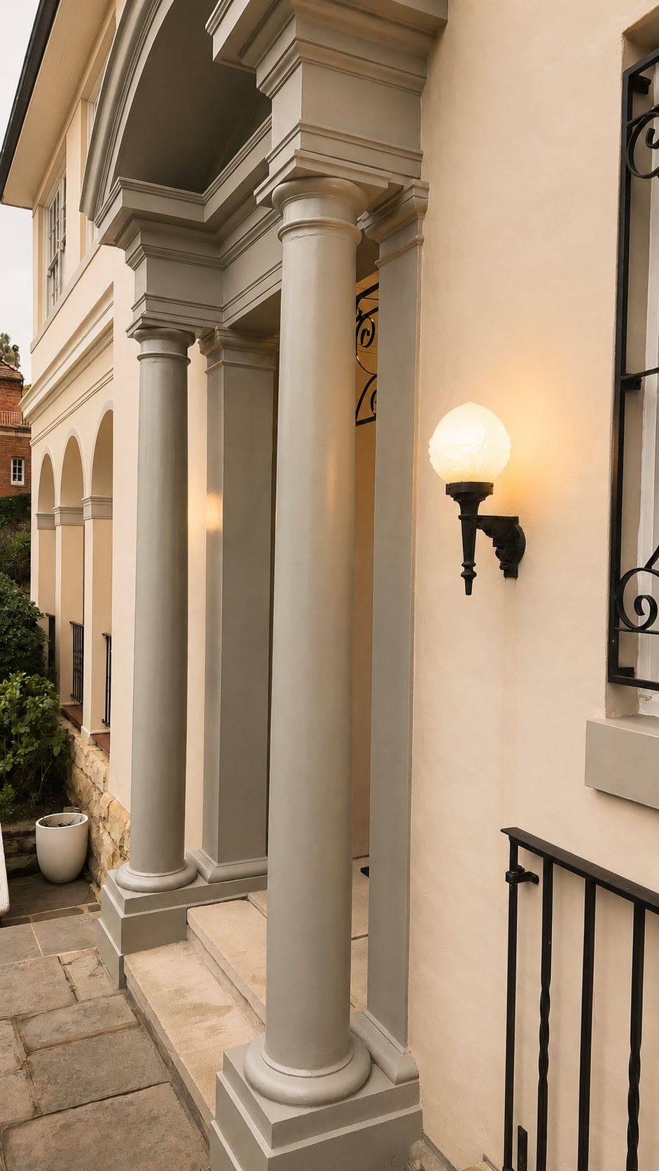 Columned entrance porch with a wall lantern